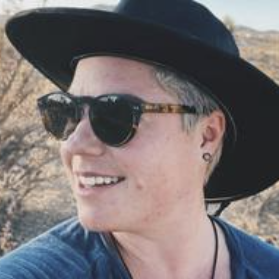 Theo smiling and looking to the left of camera wearing sunglasses and black hat